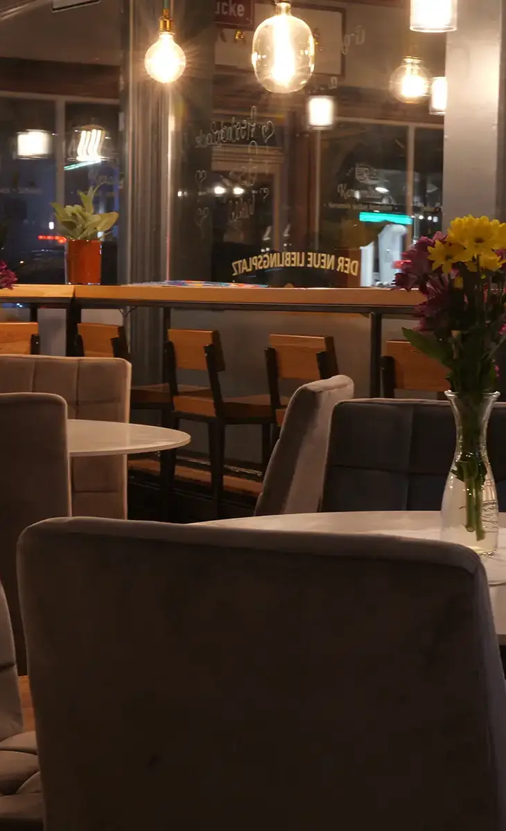 Innenansicht bei Bernadette mit Tischen und Bartresen am Fenster